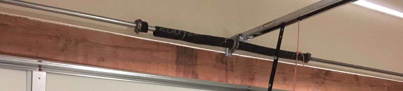 Broken torsion garage door spring before replacement in The Woodlands, TX home