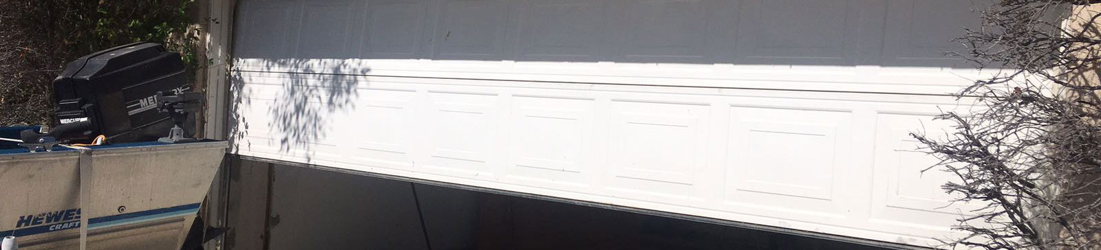 Old garage door stuck and damaged before replacement in Katy, Texas